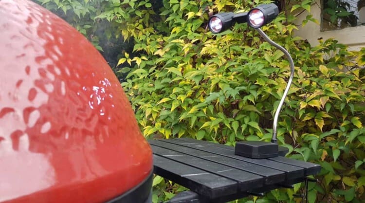Flexible grill light attached to a red Kamado Joe side table.