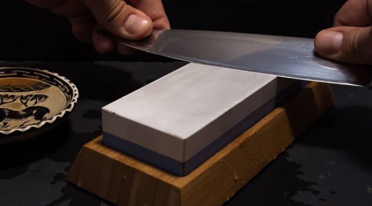 Kitchen knife being sharpened on a whetstone