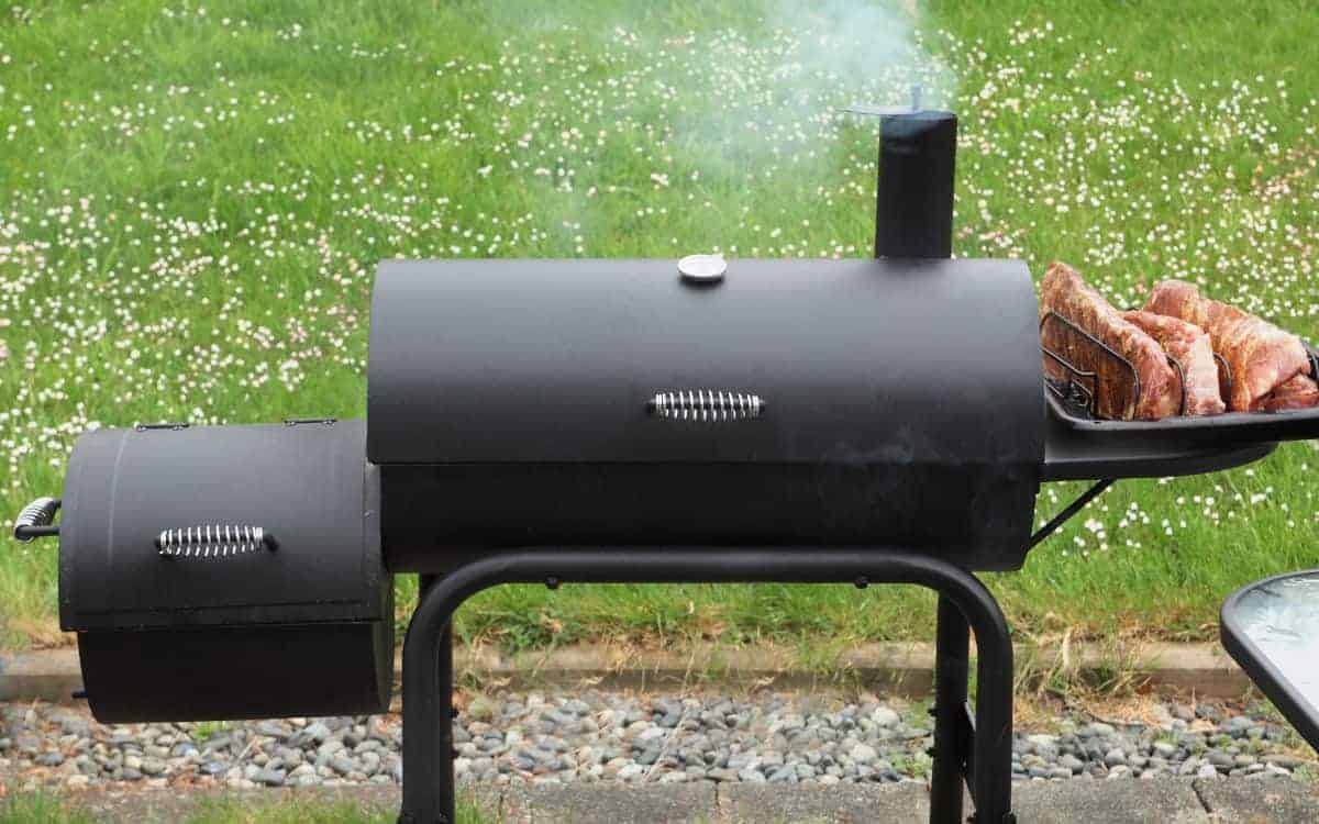 Close up of black offset smoker against grass background
