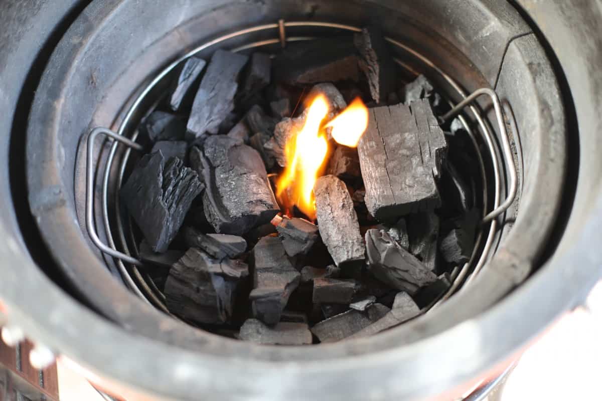 Kick ash basket in a kamado grill, full of coals with the center .