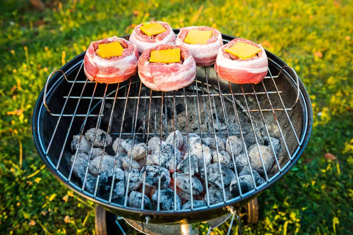 Beer can burgers, wrapped in bacon, being grilled indirect with charc.