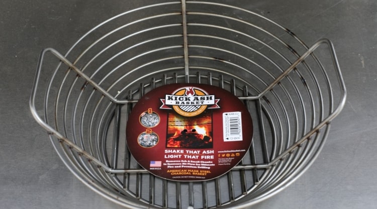 A kick ash basket on a stainless steel metal table.
