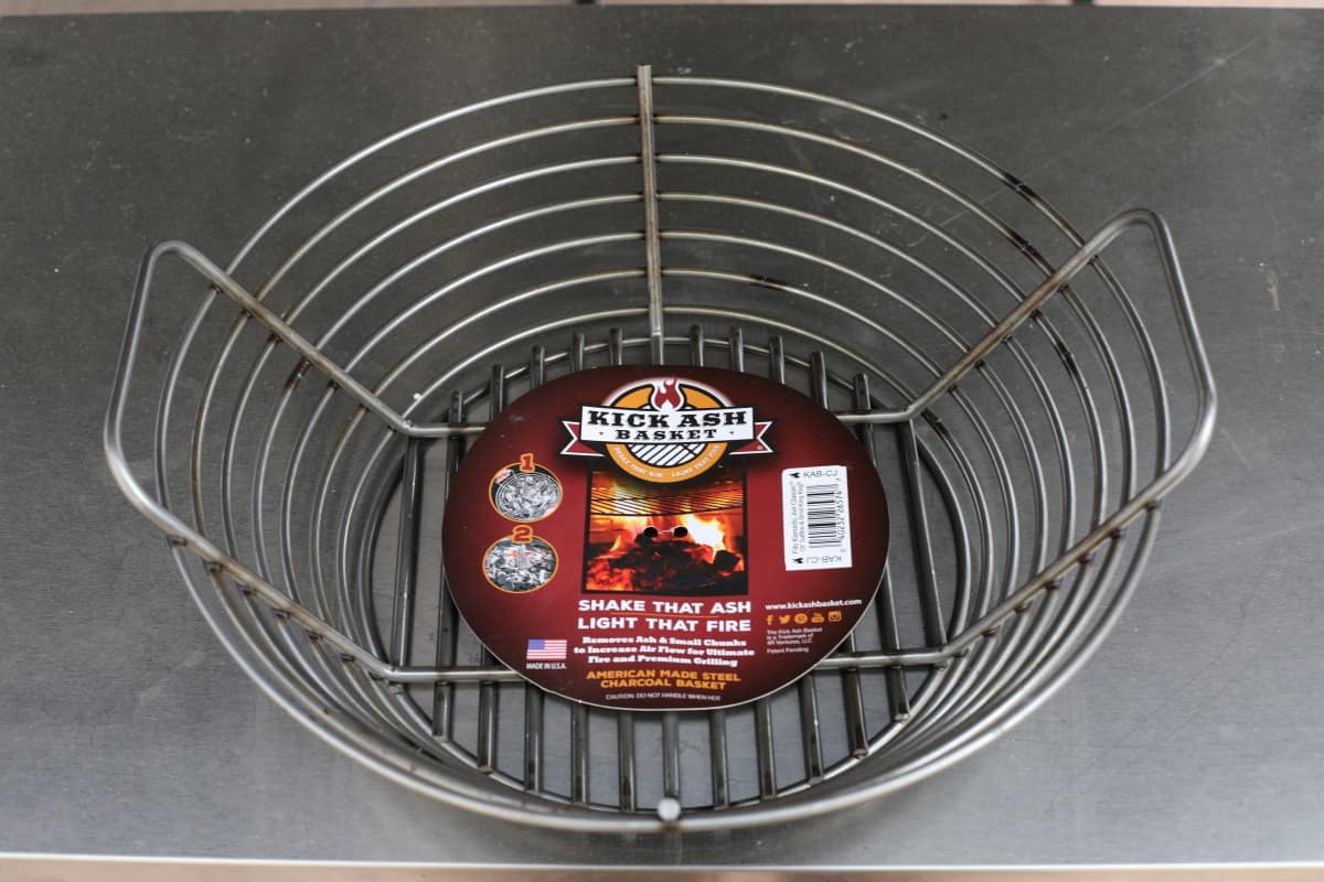 A kick ash basket on a stainless steel metal table.