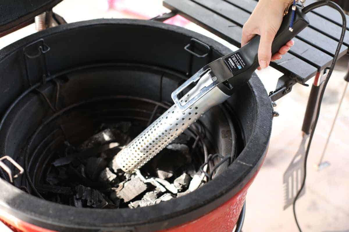 Looftlighter held in a kamado Joe, about to light lumpwood charcoal.