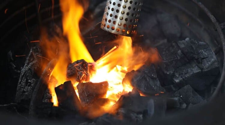 The end of a Looftlighter shown blowing flames on lit charcoal.