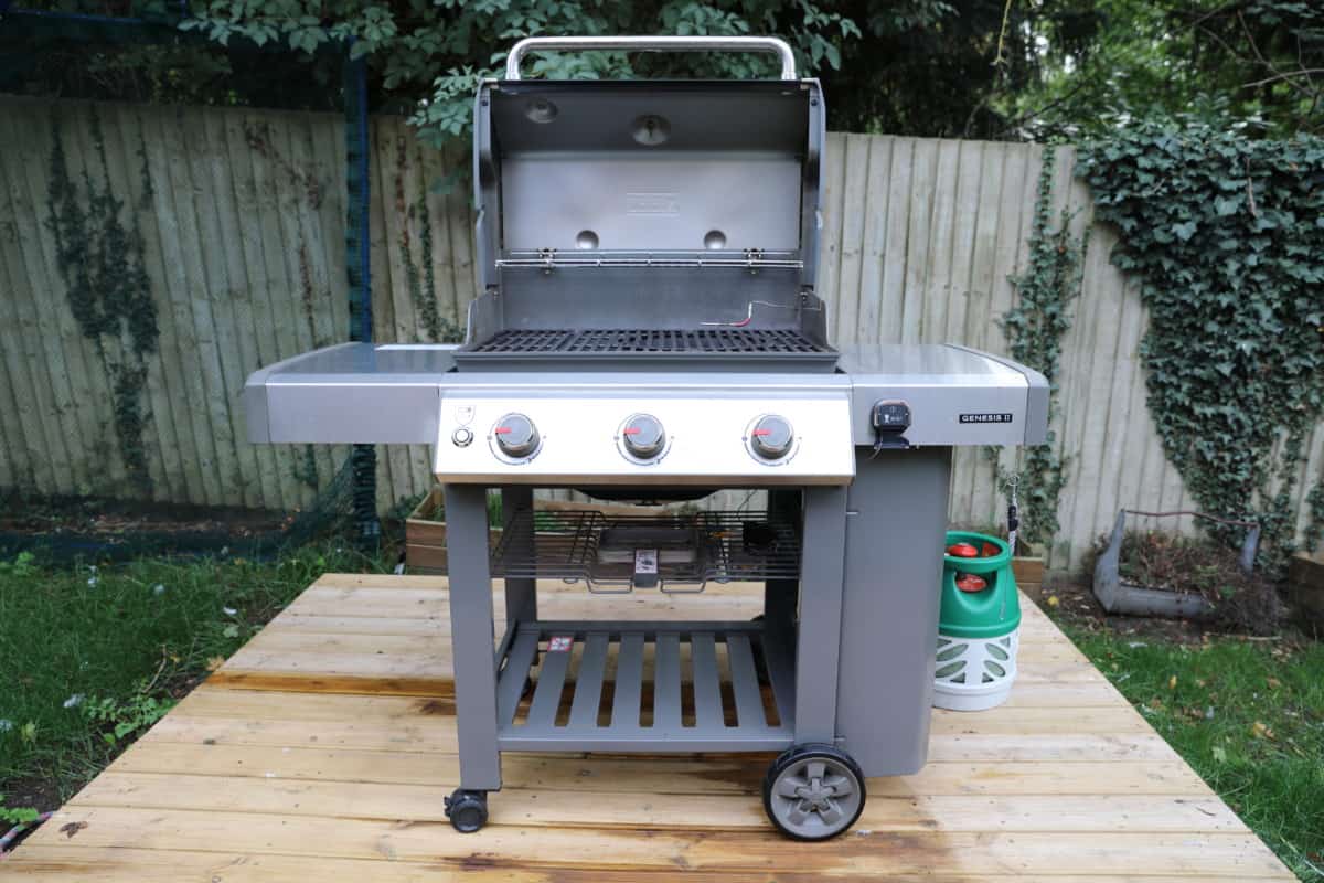 weber genesis II E-310 on a wooden deck with the lid o.