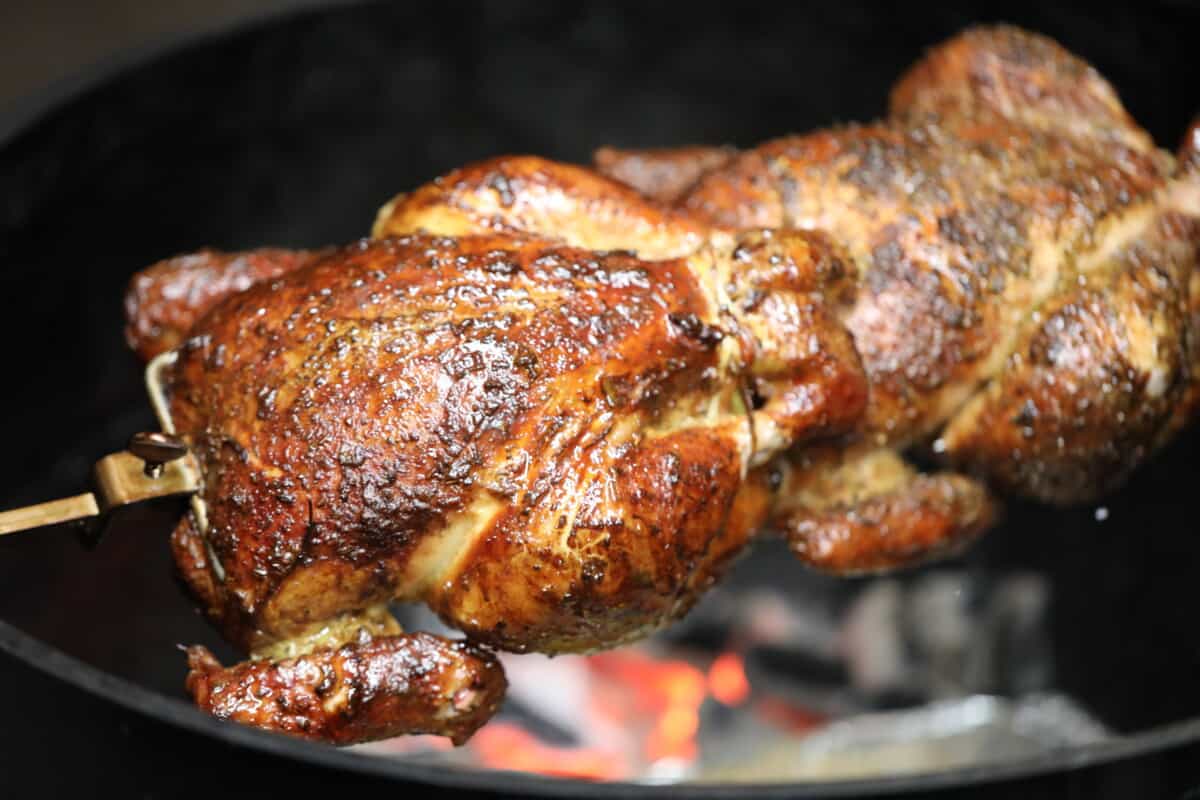 Two Partridge on a rotisserie over hot coals.