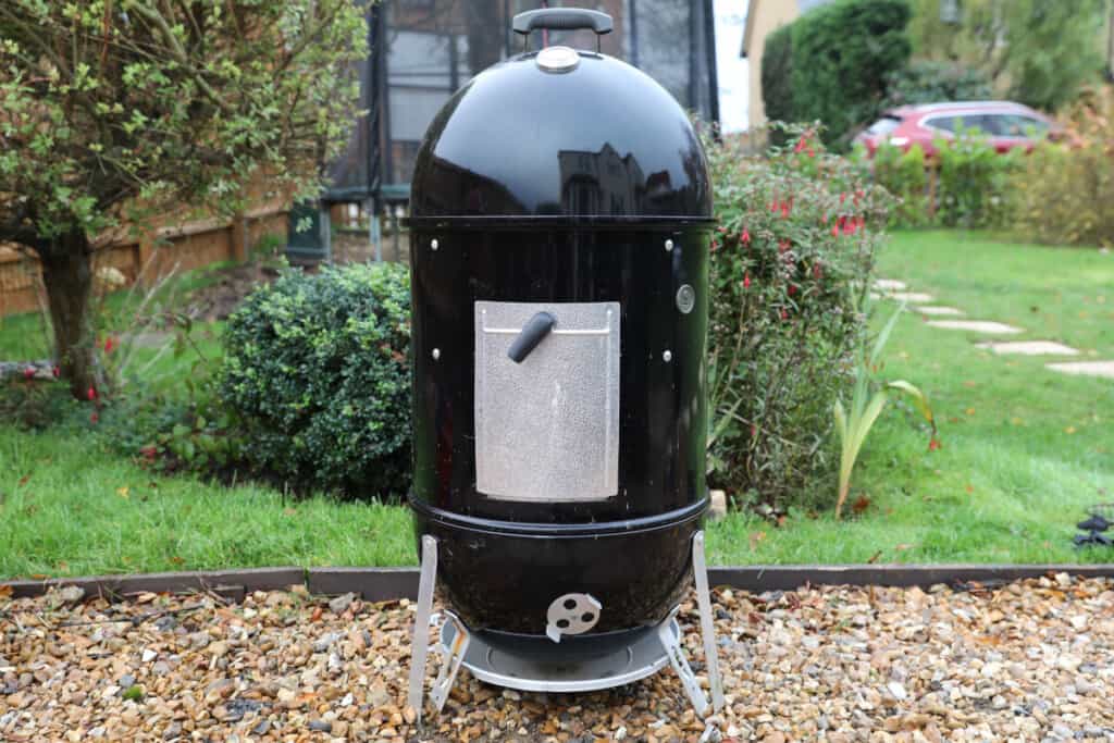 Weber Smokey Mountain smoker in a garden on a gravel path