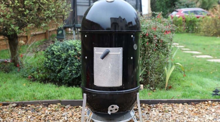 Weber Smokey Mountain smoker in a garden on a gravel path