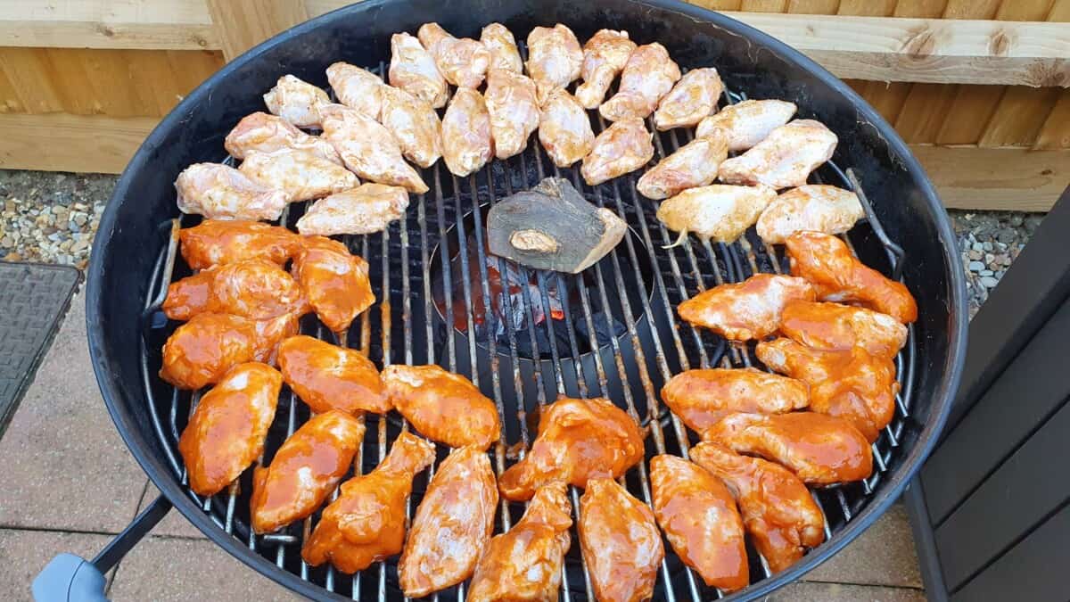 Two differently rubbed lots of wings on the Weber Kettle charcoal grill, just about to start cooking.