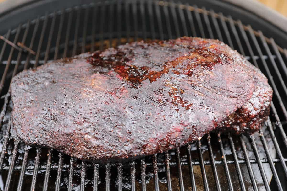 An unwrapped, partly smoked brisket on a kamado gr.