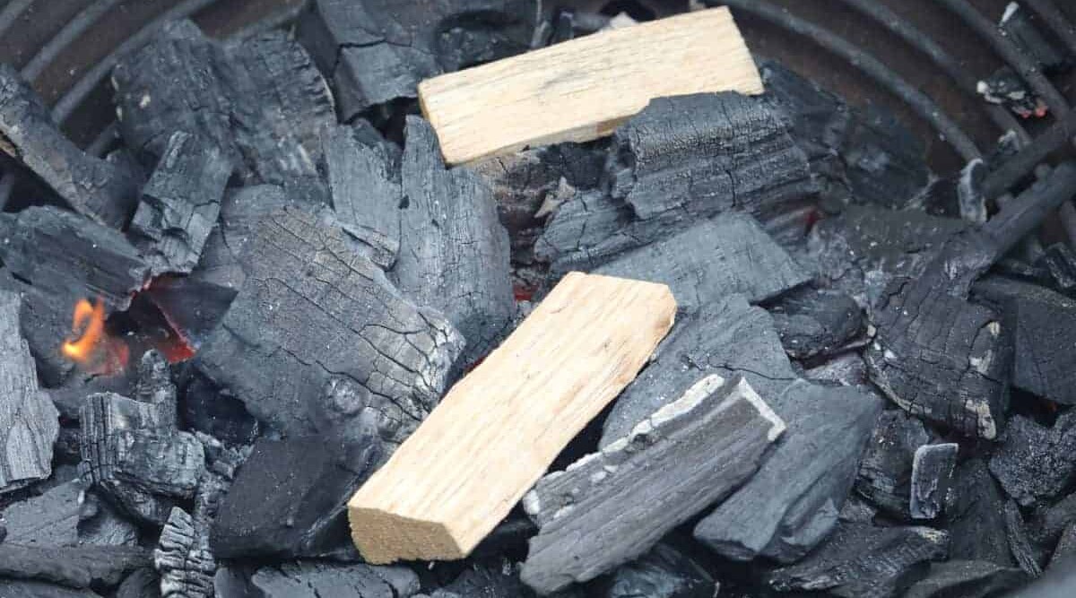 2 chunks of smoking wood on a bed of charcoal.