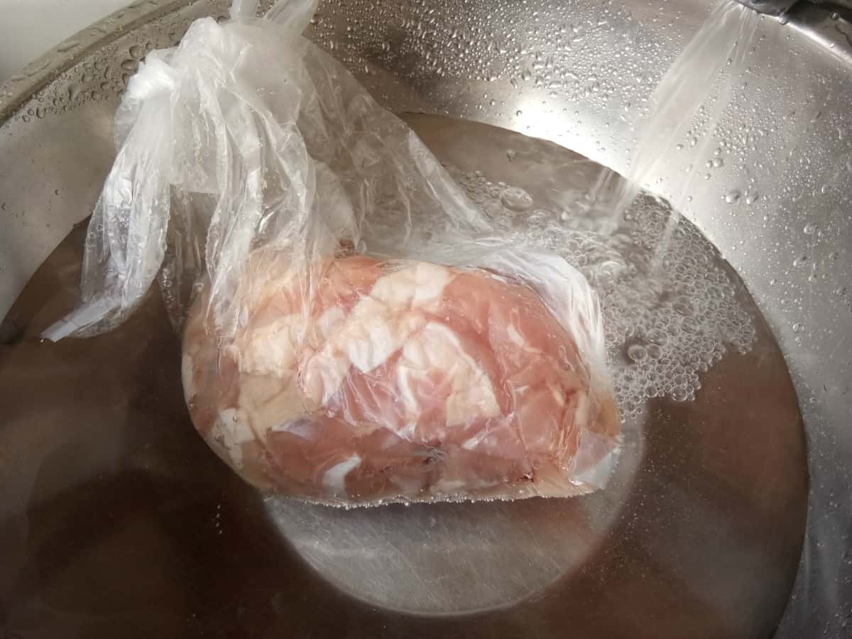 defrosting a bag of frozen chicken in water