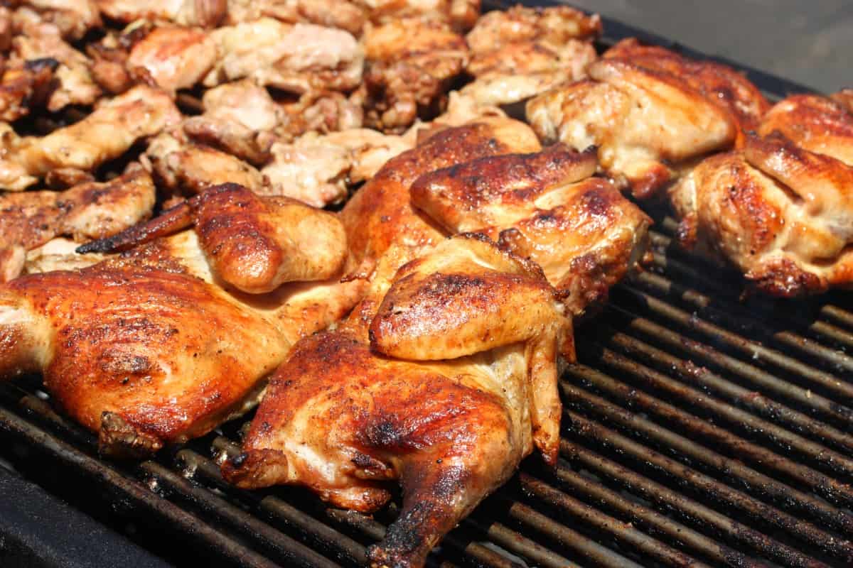 Different cuts of chicken on an open grill