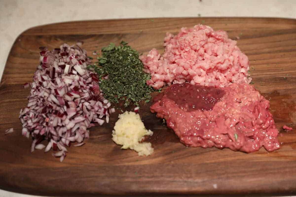 Chopped ingredients on a chopping board to make porchetta stuff.