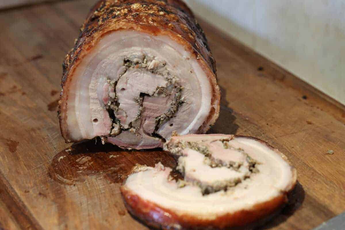 The finished porchetta, sliced to show the rolls of pork and stuffing from the end