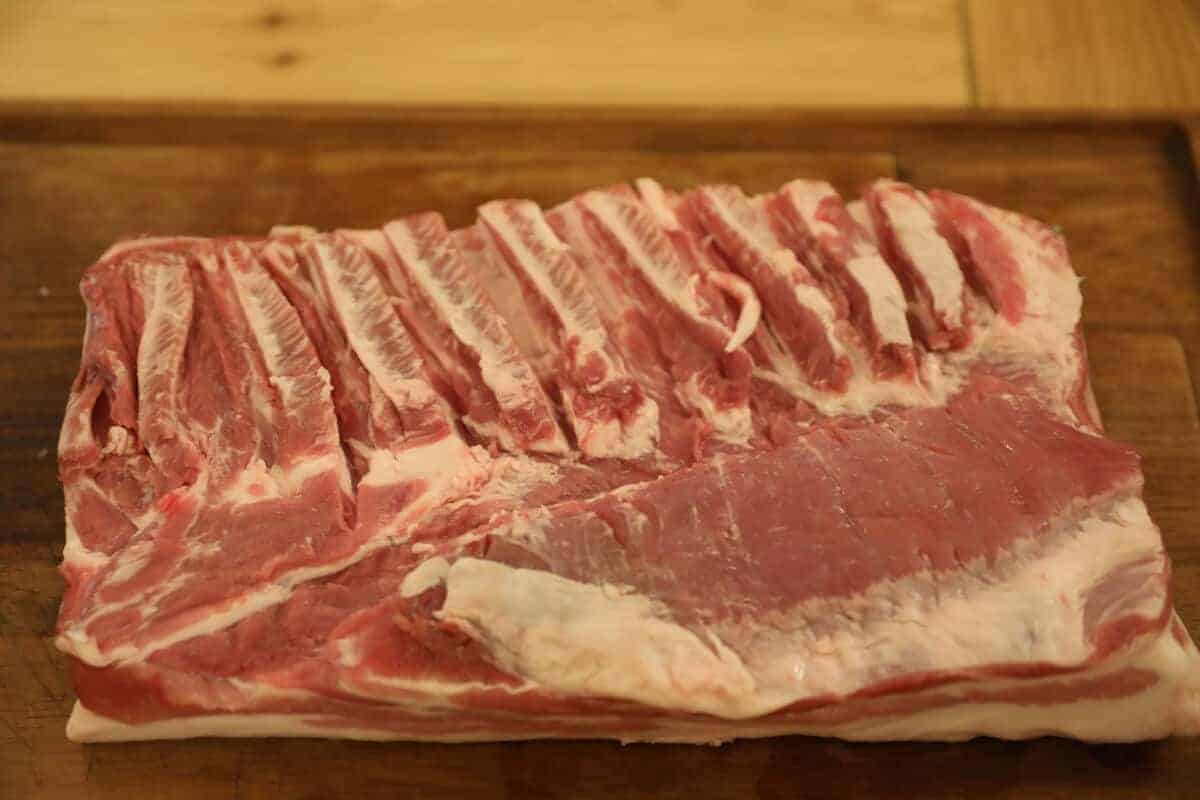 Pork belly with rib meat on a wooden chopping board