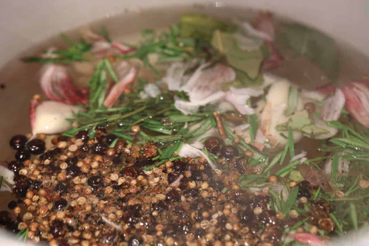 Peppercorns, thyme, rosemary, onion and garlic in boiling water.