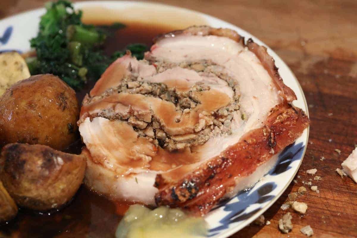 Porchetta served with cabbage, potatoes, apple sauce and gr.