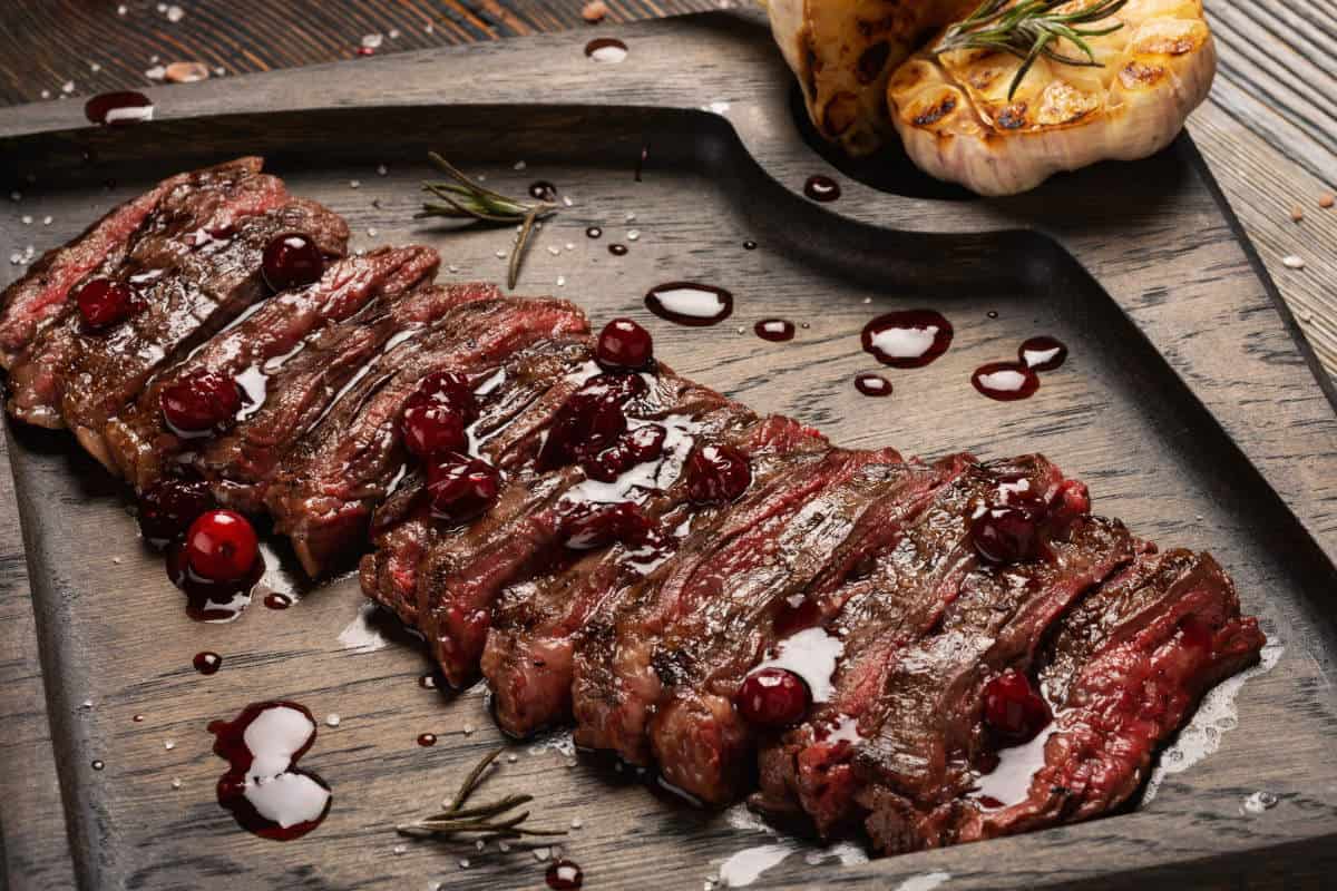 Rare grilled skirt steak, with grilled garlic halves