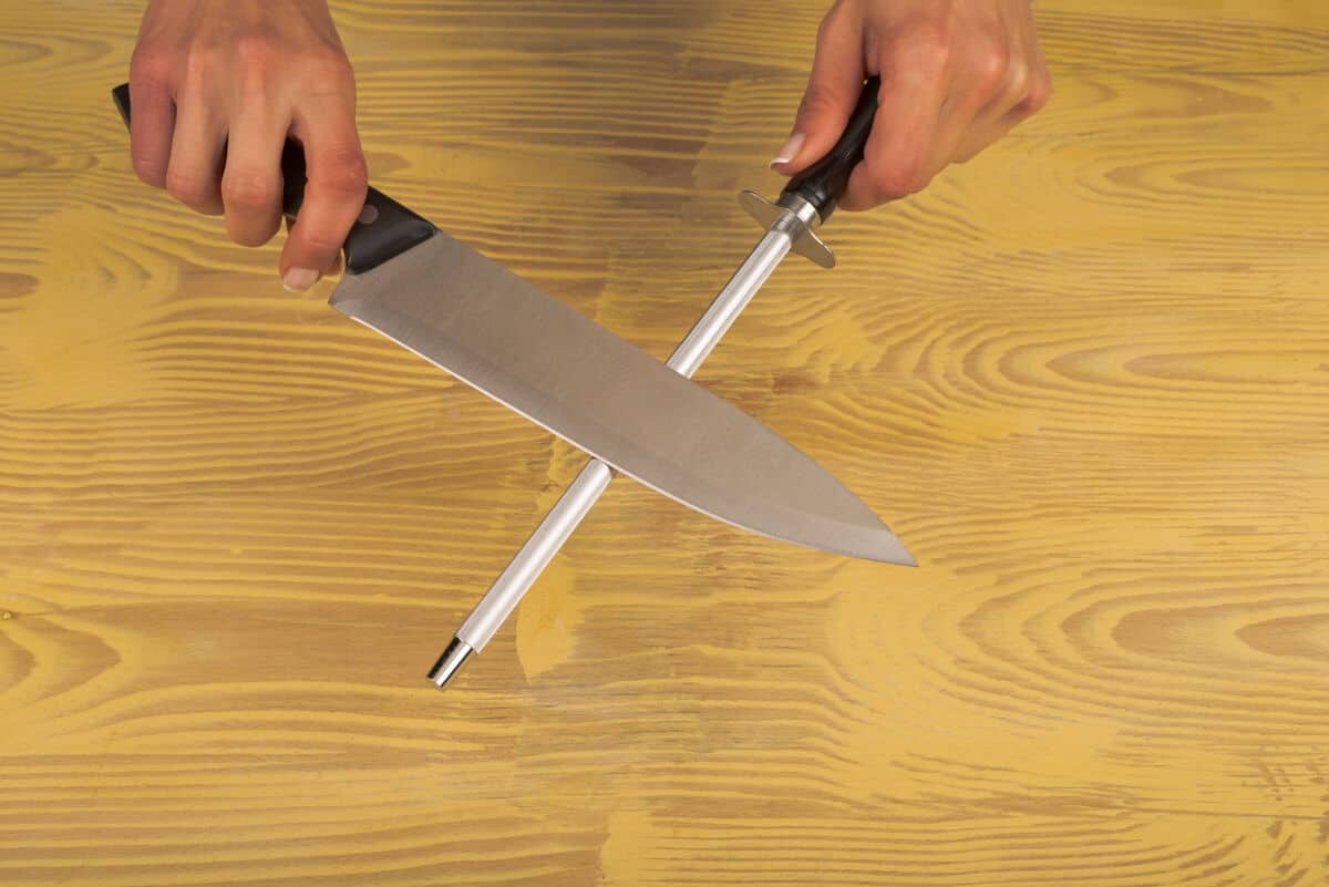 Image of a knife sharpening steel being used to hone a kitchen kn.