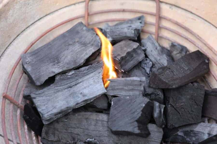 Close up of lump charcoal slowly lighting in a kamado gr.