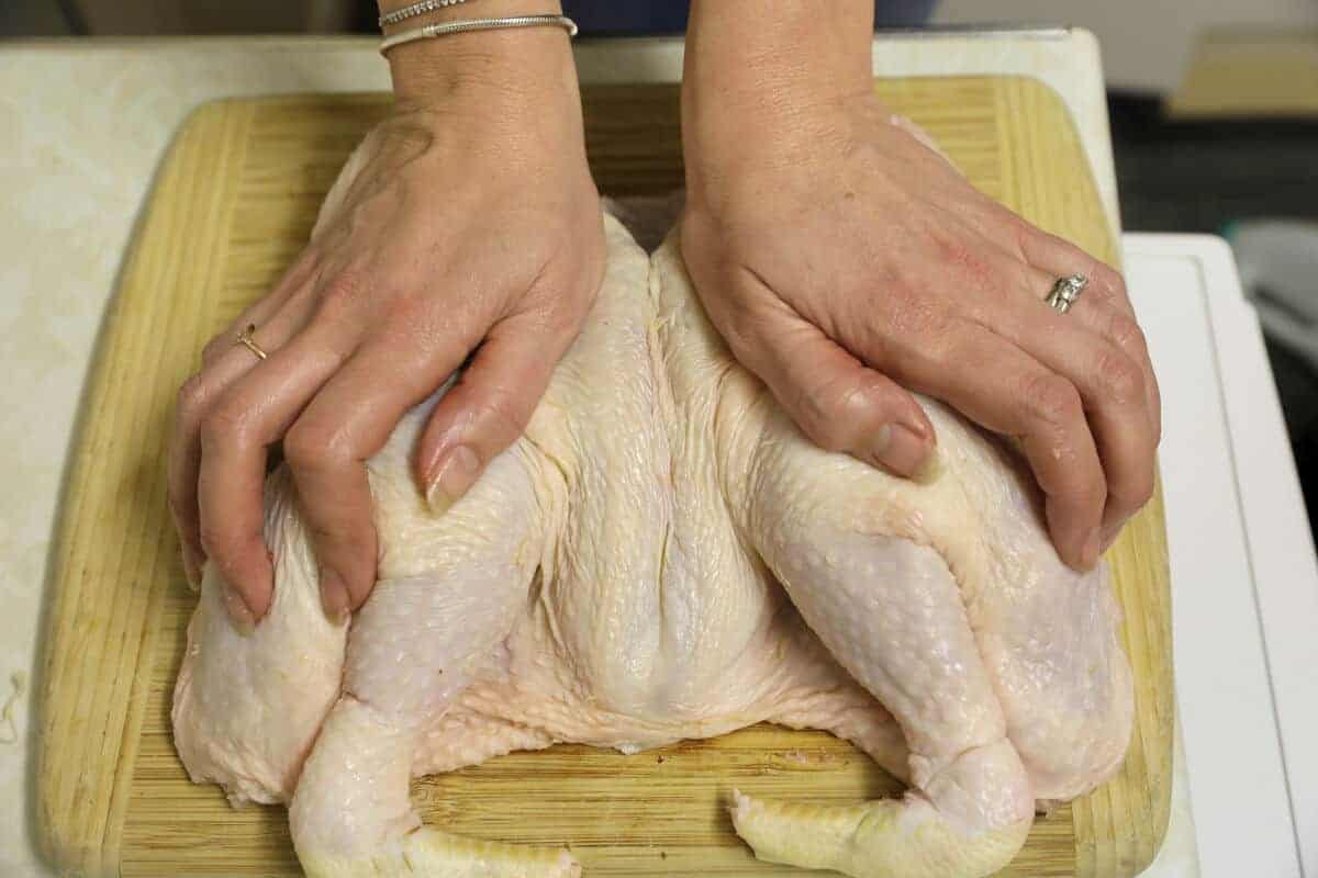 Chicken with backbone removed being squashed f.