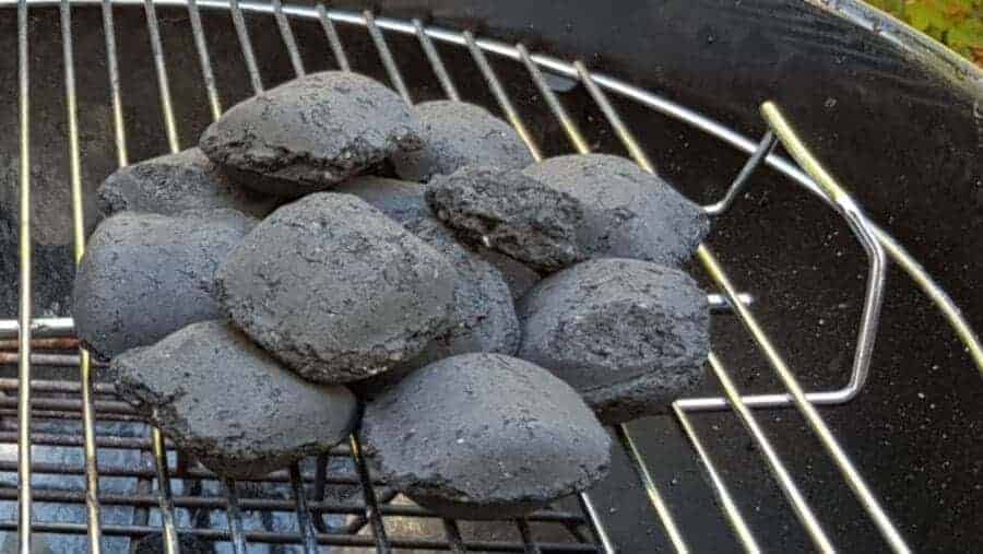 Small pile of charcoal briquettes on a stainless steel grill gr.