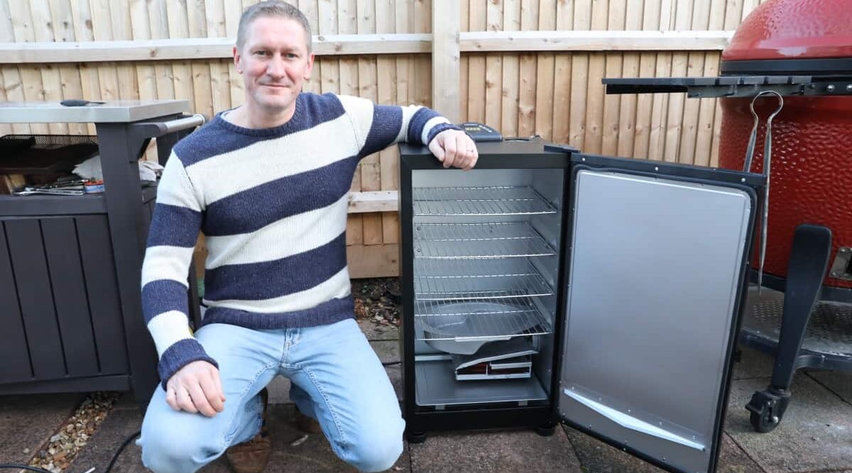 me sitting with my arm resting on my new Masterbuilt electric smoker.