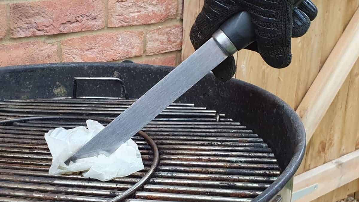 Oiling grill grates with a paper towel and to.