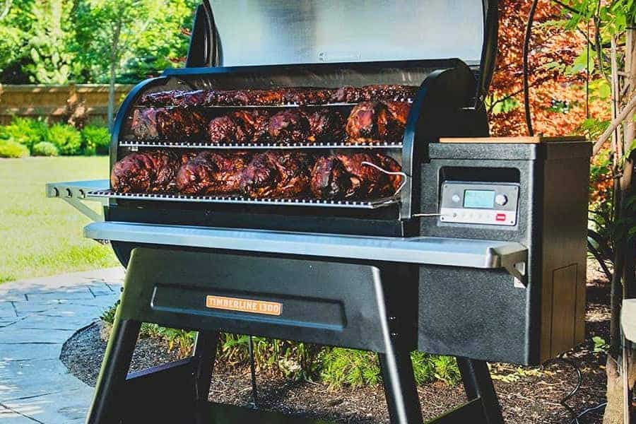 A Traeger timberline 1300 pellet grill loaded with pork butts and lid o.