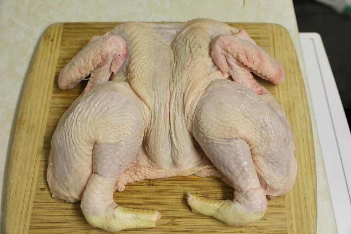a spatchcocked chicken on a cutting board