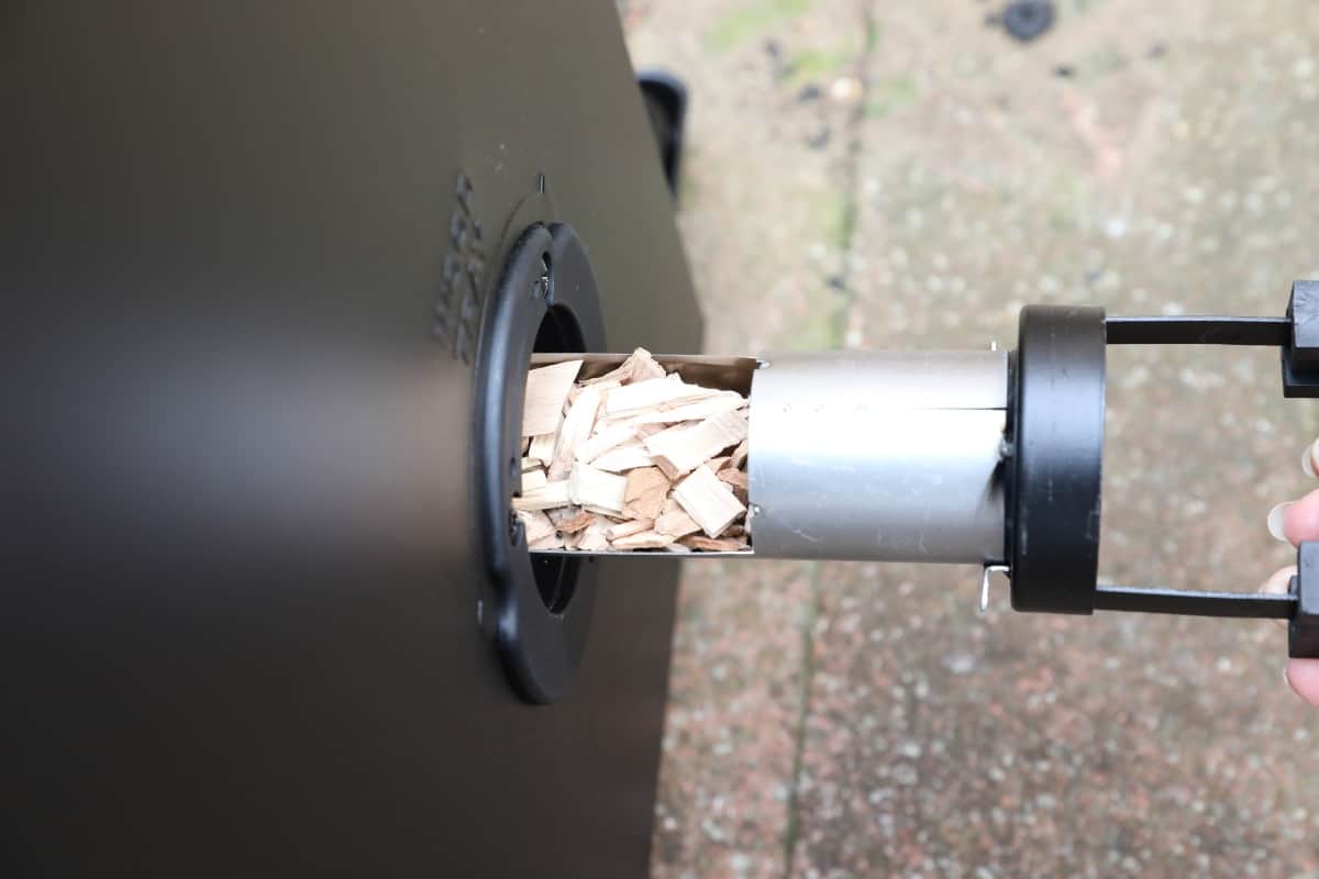 Inserting wood chips into a Masterbuilt electric smo.