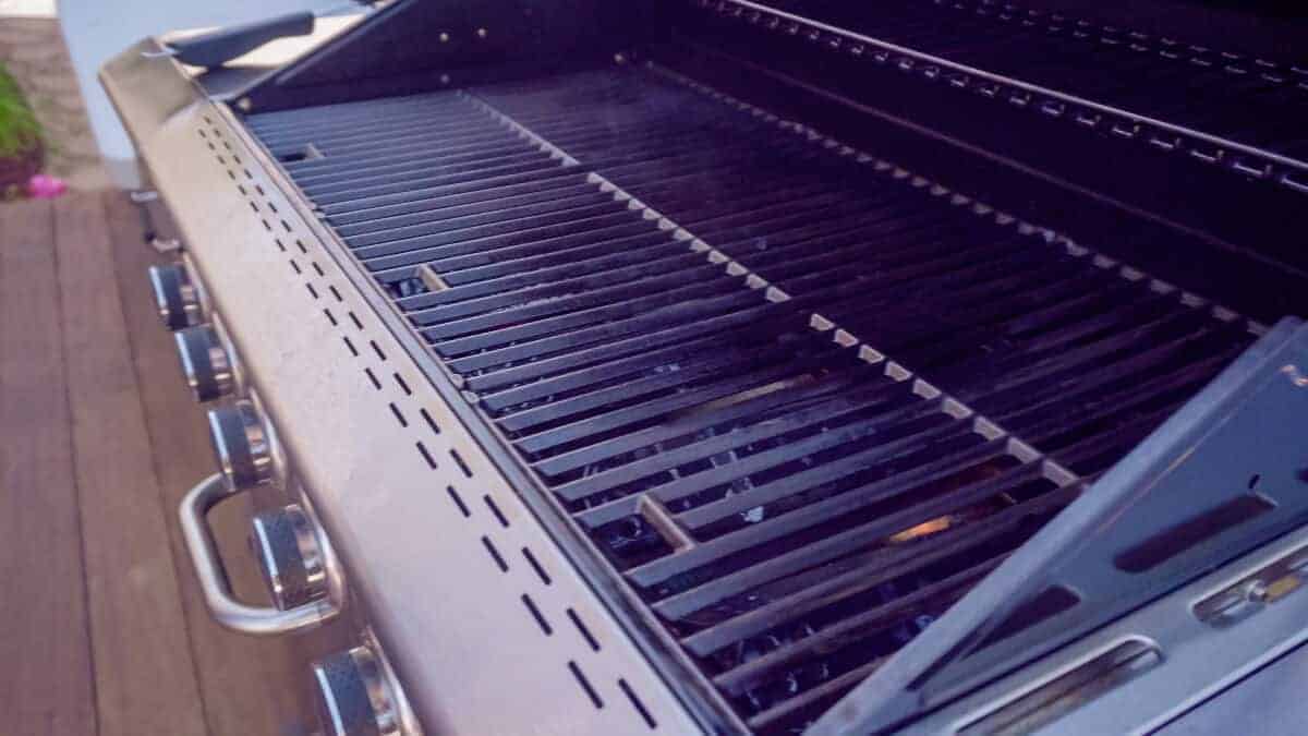 An open gas grill with no food on the gra.