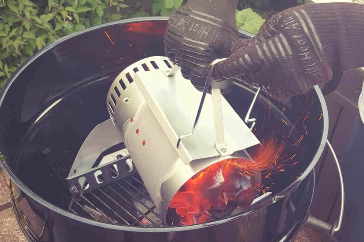 Using a charcoal chimney starter to fill a grill with co.