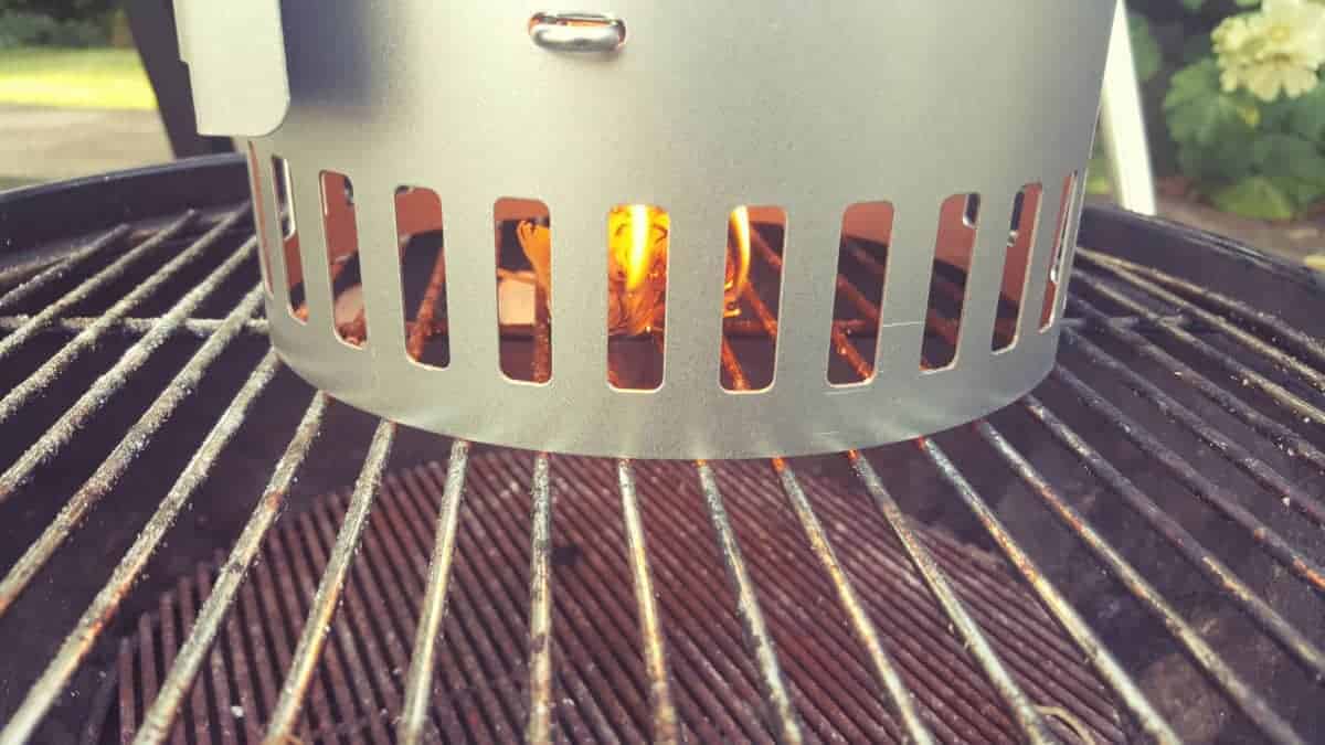 Using a charcoal chimney starter to fill a grill with co.