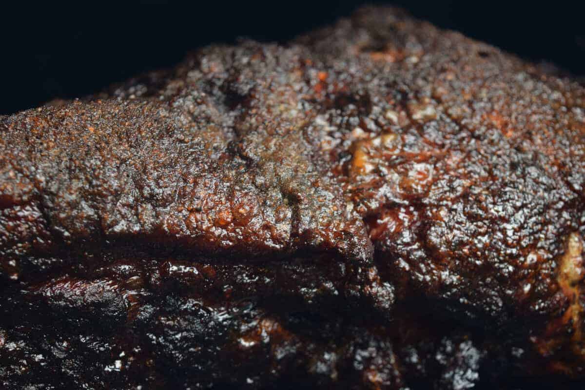 A nice, dark colored piece of BBQ meat on a smoker