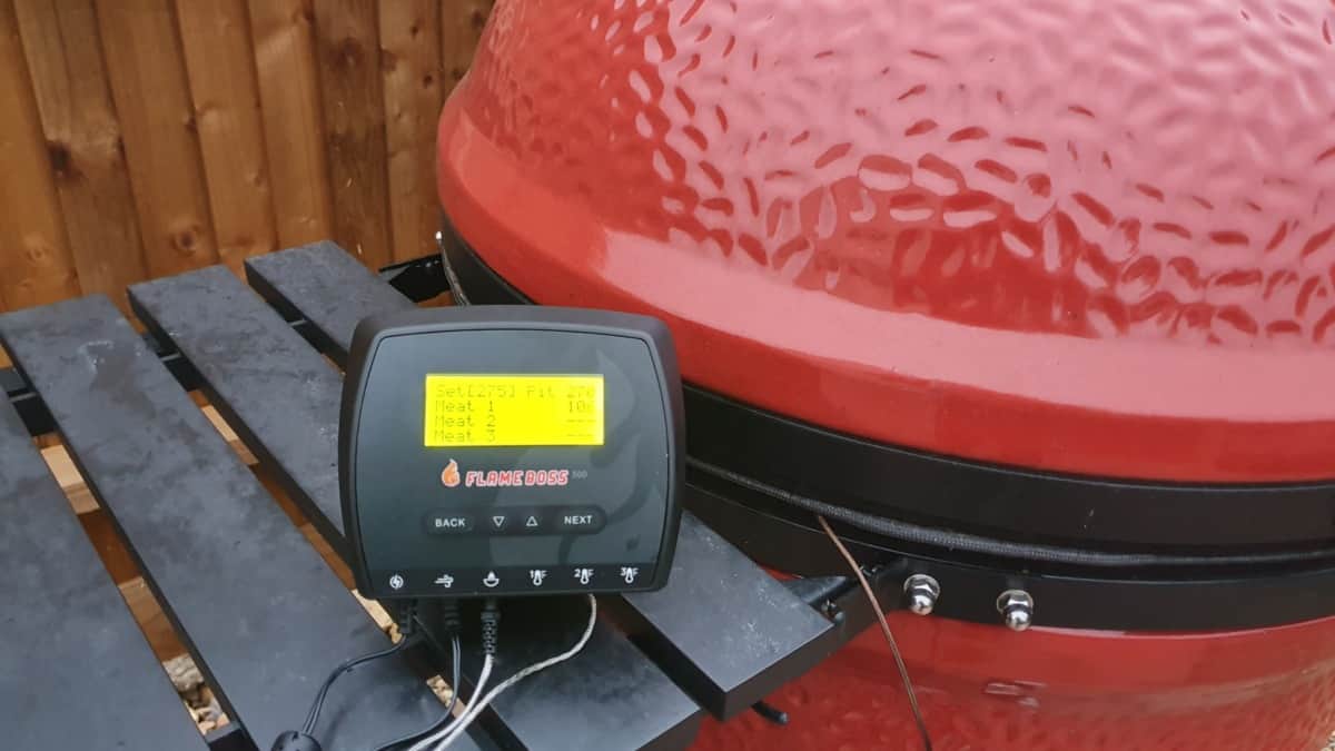 Flame boss 500 temperature controller on the side table of a Kamado Joe smoker.