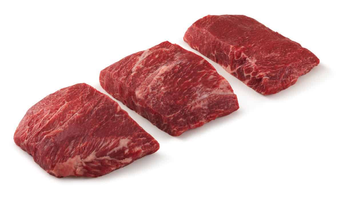 Three flat iron steaks isolated on wh.