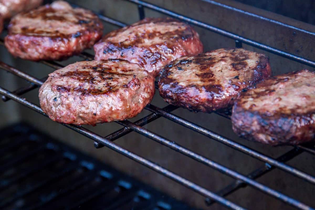 burgers on the upper racks of a pellet grill