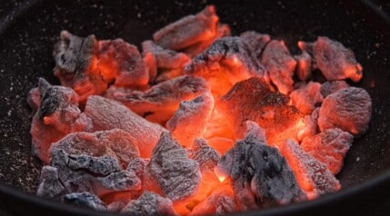 A charcoal grill full of hot, burning embers.