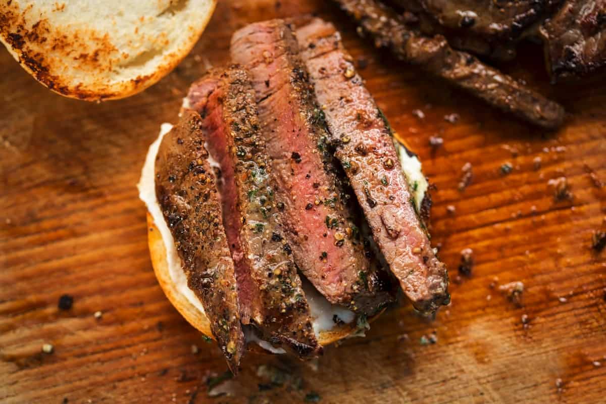 Grilled ranch steak, sliced  and placed on half a .