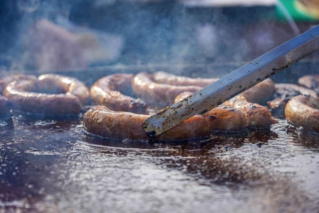 Sausages being cooked on a grid.