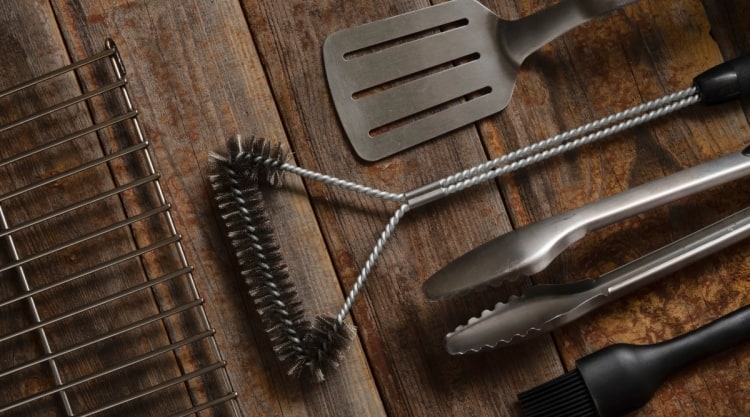 A selection of BBQ and grilling tools on a wooden table