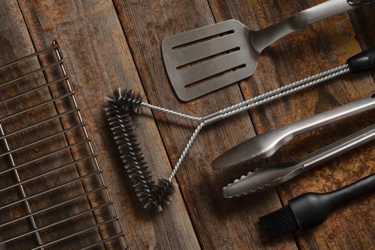 A selection of BBQ and grilling tools on a wooden table.