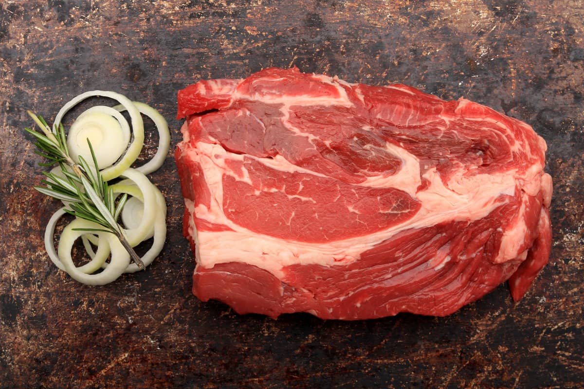 A raw blade chuck steak with sliced oni.