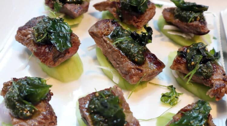 Beef BBQ bites with a green herby sauce.