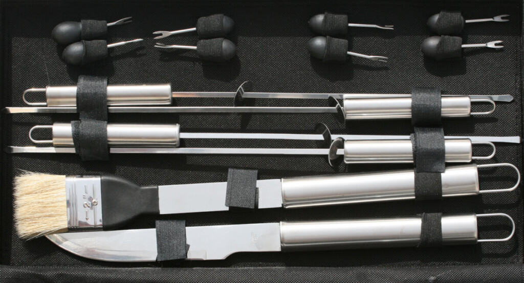 A large BBQ tool set on a dark surf.