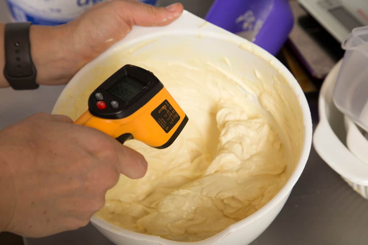 An infrared thermometer measuring the temperature of white chocol.
