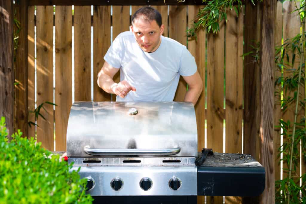 A man looking out over an infrared gas grill into the cam.